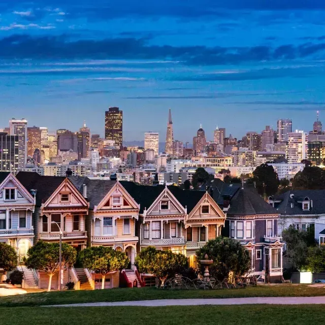 Le famose Painted Ladies di Alamo Square sono ritratte di fronte allo skyline di San Francisco al tramonto.